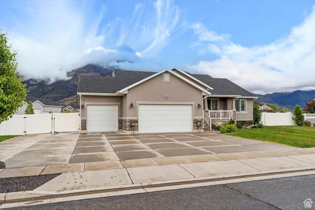 1254 N 150 E, Harrisville, UT 84404 - view of front facade featuring stucco siding, a gate, an attached garage, driveway, and a mountain view