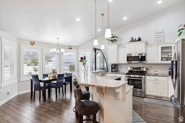 1254 N 150 E, Harrisville, UT 84404 - kitchen with stainless steel appliances, a chandelier, vaulted ceiling, tasteful backsplash, and a kitchen breakfast bar