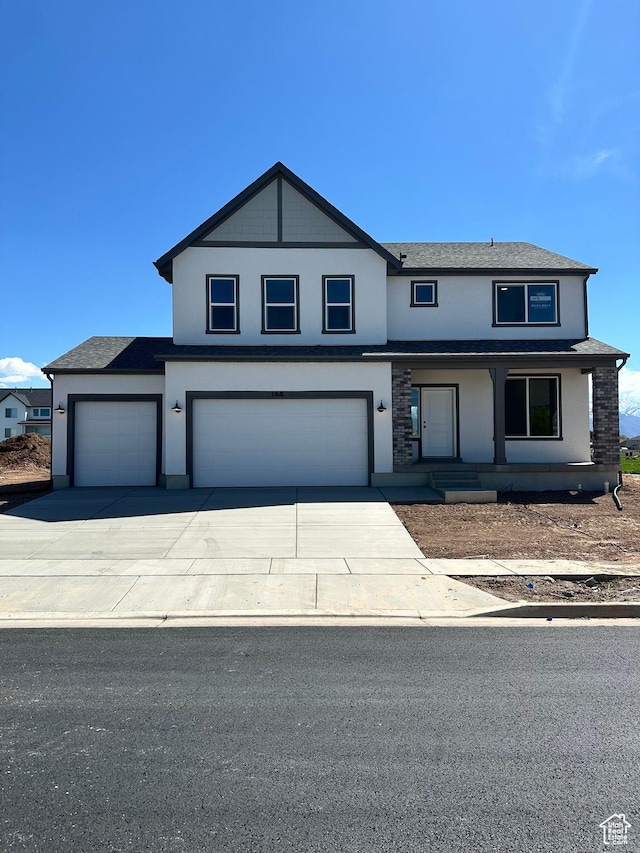 168 N 825 W Unit 8, Clearfield, UT 84015 - view of front of house featuring stucco siding, driveway, an attached garage, covered porch, and roof with shingles