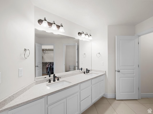 3388 W Rocky Peak Way S, Jordan, UT 84095 - full bathroom featuring tile patterned floors, toilet, double vanity, a walk in closet, and baseboards