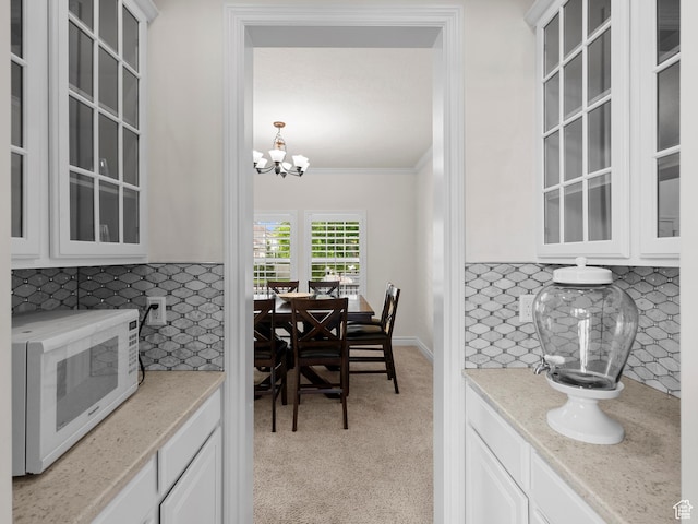 3388 W Rocky Peak Way S, Jordan, UT 84095 - kitchen with white microwave, tasteful backsplash, white cabinetry, glass insert cabinets, and crown molding