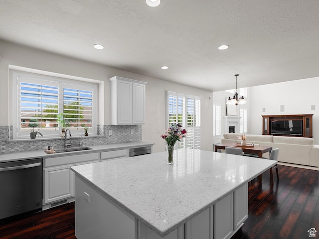 3388 W Rocky Peak Way S, Jordan, UT 84095 - kitchen featuring stainless steel dishwasher, dark wood-type flooring, a sink, decorative backsplash, and a center island