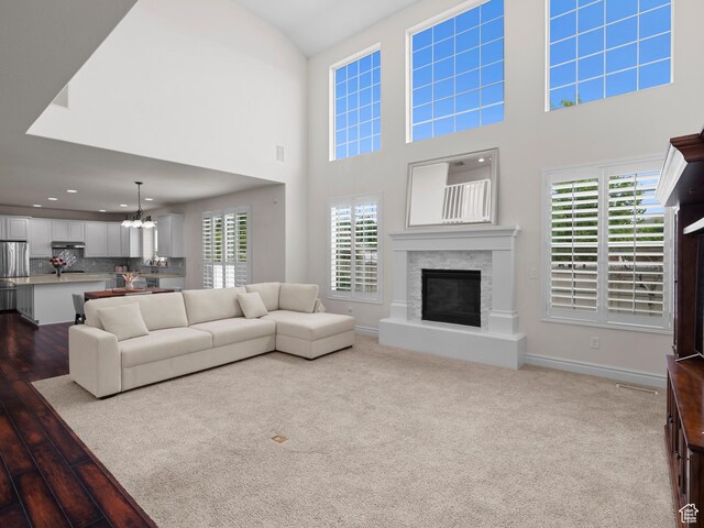 3388 W Rocky Peak Way S, Jordan, UT 84095 - living area featuring a glass covered fireplace, a chandelier, wood finished floors, recessed lighting, and baseboards