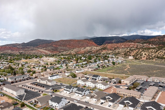aerial view of property's location featuring a mountainous background and nearby suburban area