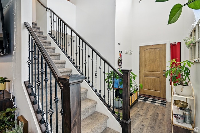 entrance foyer with a high ceiling, wood finished floors, and stairs