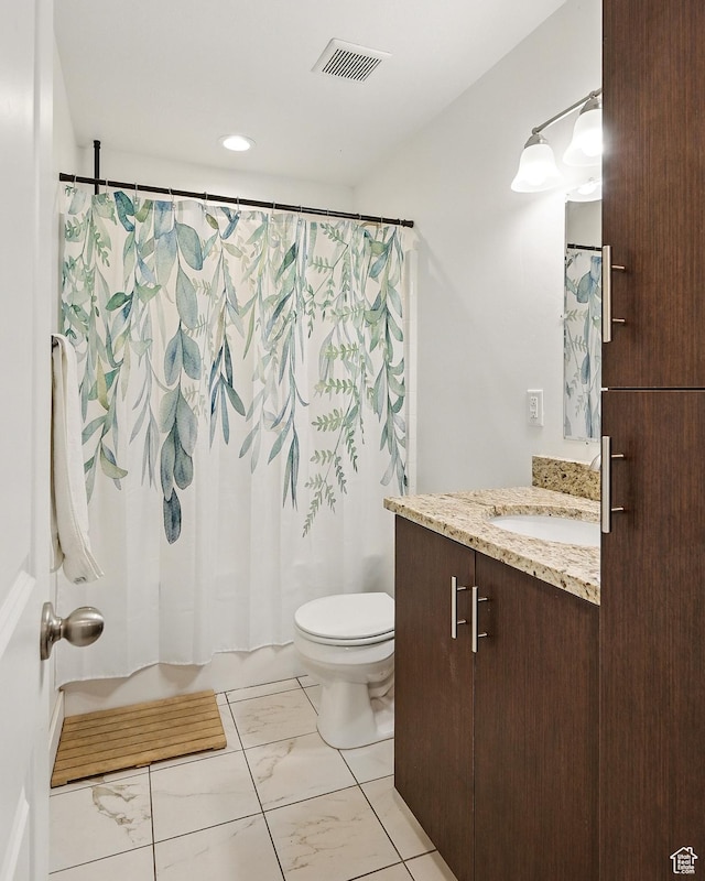 bathroom featuring marble finish flooring, toilet, shower / bath combo with shower curtain, and vanity