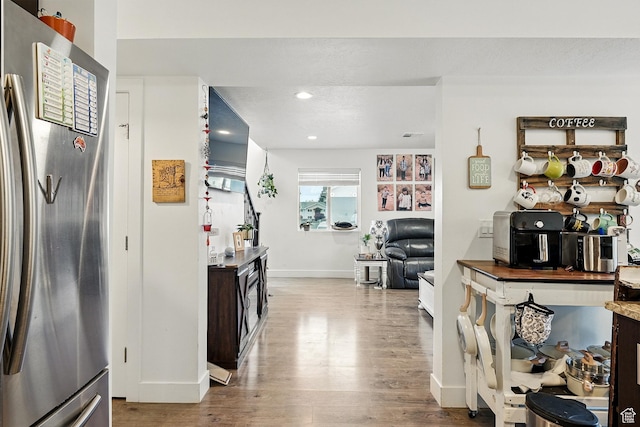 kitchen featuring freestanding refrigerator, baseboards, wood finished floors, and recessed lighting