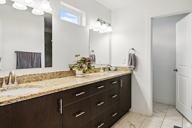 bathroom with marble finish floors, double vanity, and baseboards