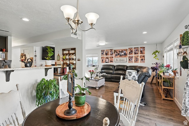 dining room featuring healthy amount of natural light, wood finished floors, recessed lighting, a chandelier, and a textured ceiling