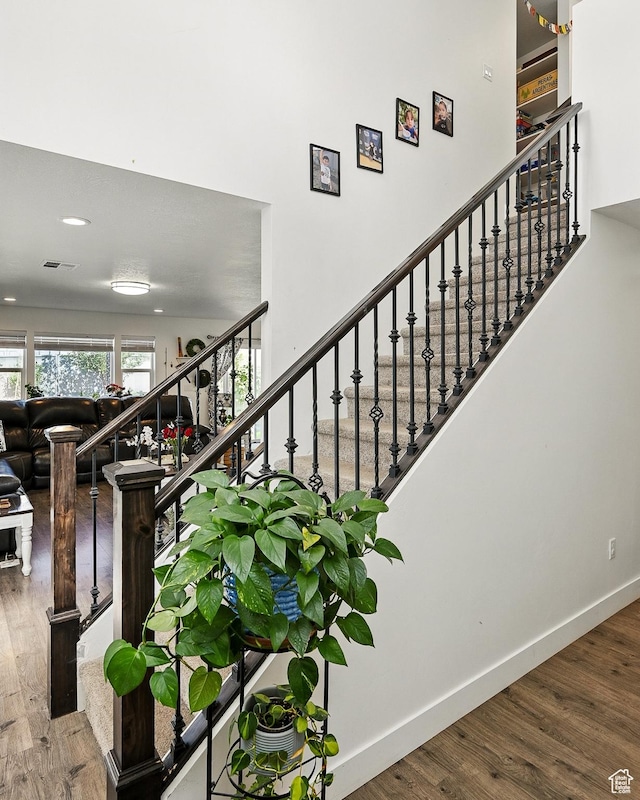 stairs with wood finished floors and baseboards