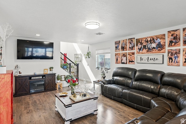 living area featuring stairs and dark wood-style flooring