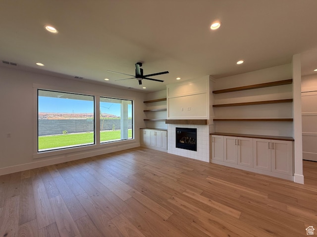 unfurnished living room with ceiling fan, light wood-type flooring, recessed lighting, a fireplace, and baseboards