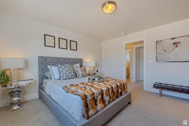 bedroom with light colored carpet and baseboards