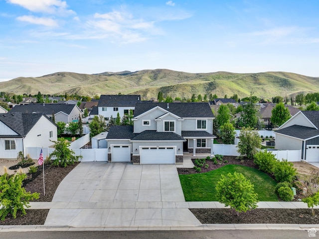 view of front of property with a residential view, fence, driveway, and a mountain view