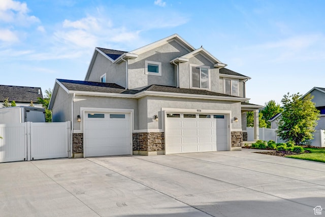 view of front of property with stucco siding, driveway, a garage, a gate, and fence