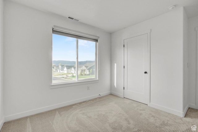 unfurnished bedroom featuring light colored carpet and baseboards