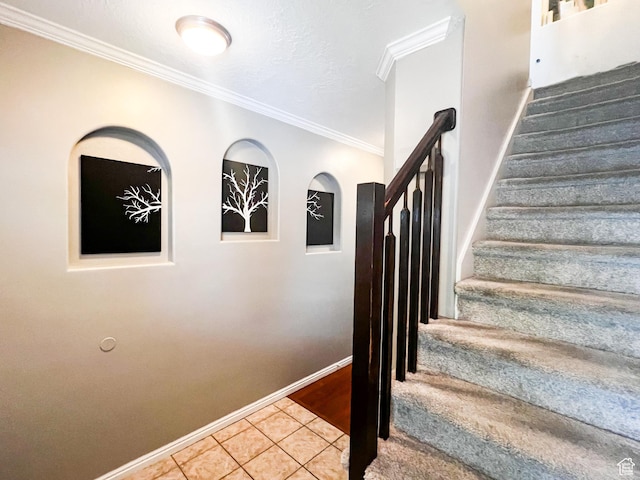 stairs with tile patterned flooring, crown molding, and baseboards