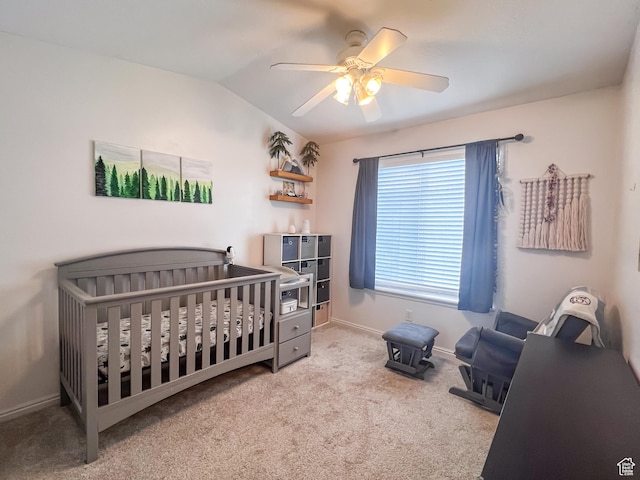 carpeted bedroom featuring vaulted ceiling, ceiling fan, a nursery area, and baseboards