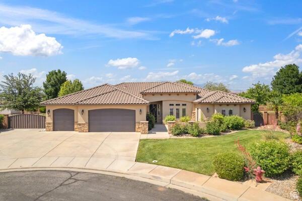 417 E Stonehedge Cir, Washington, UT 84780 - mediterranean / spanish-style home featuring stucco siding, stone siding, an attached garage, driveway, and a tile roof