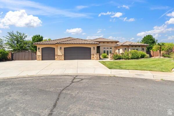 417 E Stonehedge Cir, Washington, UT 84780 - mediterranean / spanish-style house featuring stucco siding, a garage, concrete driveway, stone siding, and a tiled roof
