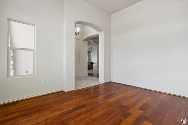 417 E Stonehedge Cir, Washington, UT 84780 - empty room featuring arched walkways, wood finished floors, and baseboards