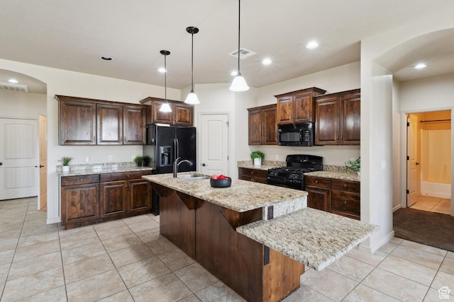417 E Stonehedge Cir, Washington, UT 84780 - kitchen featuring black appliances, arched walkways, a kitchen island with sink, light tile patterned floors, and dark brown cabinetry