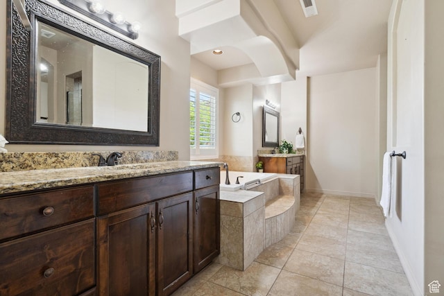 417 E Stonehedge Cir, Washington, UT 84780 - bathroom featuring two vanities, a garden tub, baseboards, and tile patterned floors