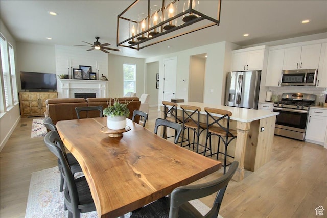 352 N 75 E, Kaysville, UT 84037 - dining area with ceiling fan, light wood-style floors, a fireplace, baseboards, and recessed lighting