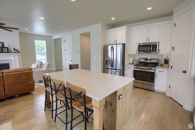352 N 75 E, Kaysville, UT 84037 - kitchen featuring stainless steel appliances, open floor plan, light wood-type flooring, a breakfast bar, and recessed lighting