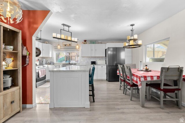 8521 W 3100 S, Magna, UT 84044 - kitchen with appliances with stainless steel finishes, a chandelier, healthy amount of natural light, and white cabinets