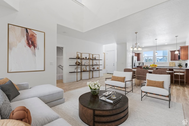 living area featuring light wood finished floors and a chandelier