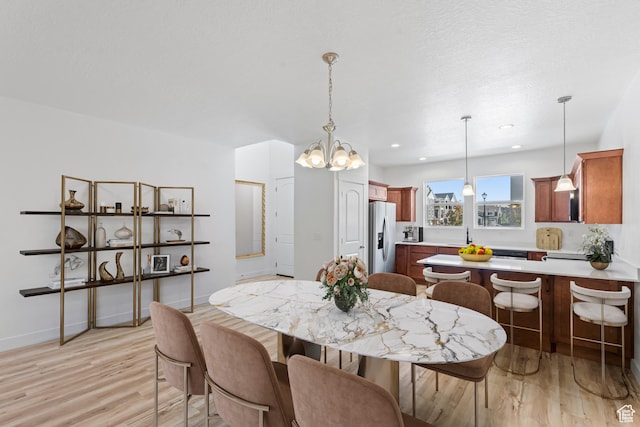 dining area with light wood-style floors, a chandelier, baseboards, and recessed lighting