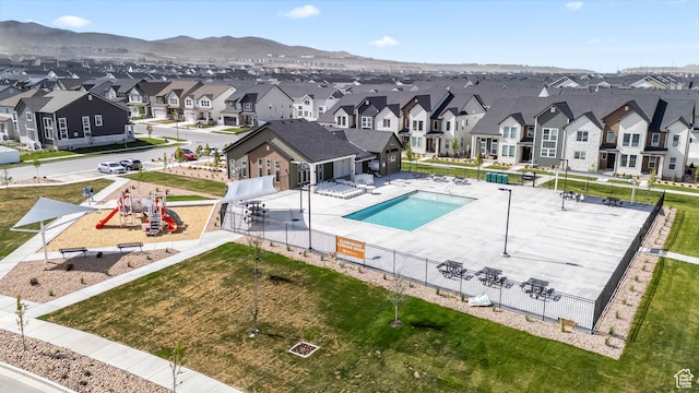 community pool featuring a residential view, fence, a mountain view, and a patio area