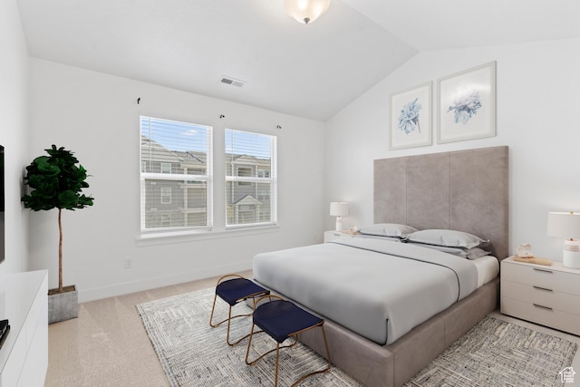 bedroom with vaulted ceiling and light carpet