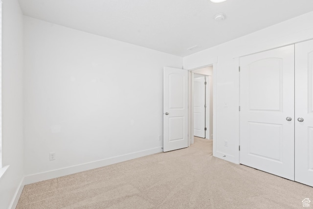 unfurnished bedroom with carpet floors, a closet, and baseboards
