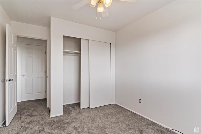 unfurnished bedroom featuring carpet floors, baseboards, a closet, and a ceiling fan