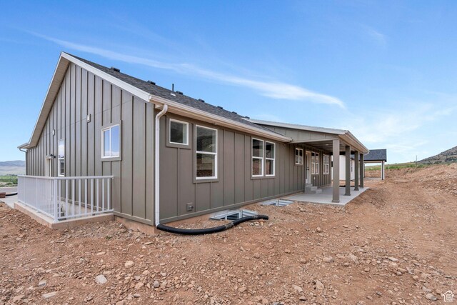 view of side of home with board and batten siding and a patio area