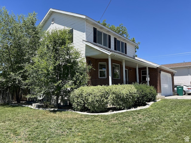 view of front of property featuring an attached garage, covered porch, brick siding, and a front yard