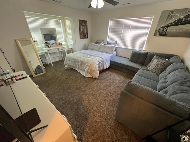 carpeted bedroom featuring multiple windows and a ceiling fan