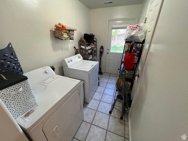 laundry area featuring washer and dryer and light tile patterned floors