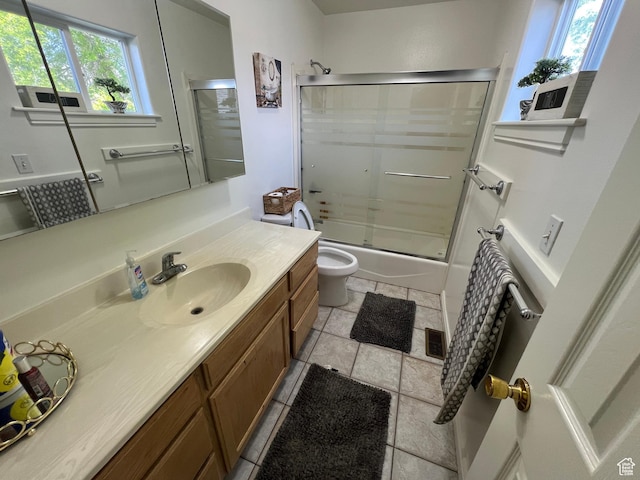 bathroom with vanity, toilet, and bath / shower combo with glass door