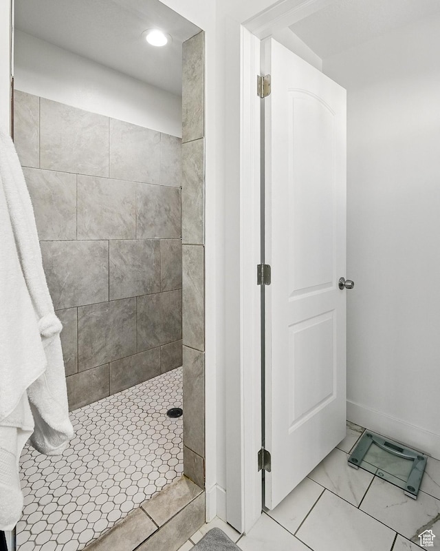 full bath featuring a tile shower, recessed lighting, and baseboards