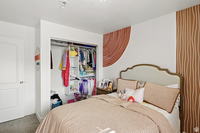 carpeted bedroom with a closet and baseboards