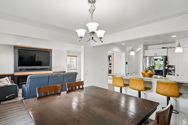dining space with a chandelier, recessed lighting, and wood finished floors