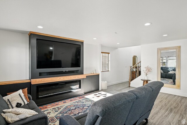 living area with recessed lighting, stairway, wood finished floors, and baseboards