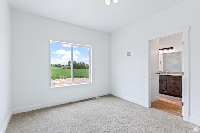 676 E 2450 N, North Logan, UT 84341 - unfurnished bedroom with light colored carpet, baseboards, a sink, and connected bathroom