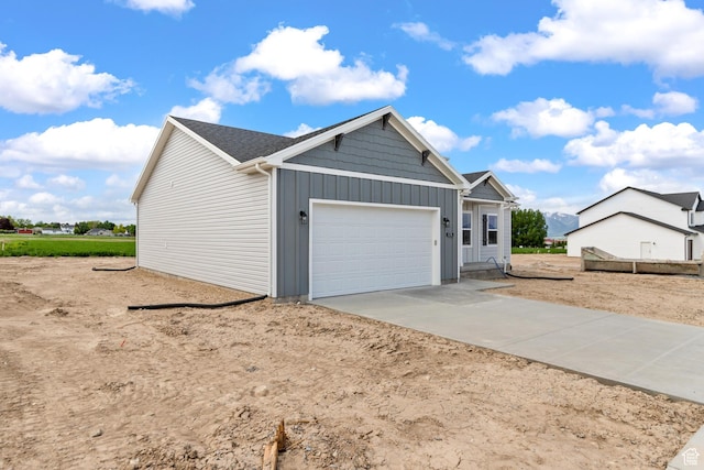 676 E 2450 N, North Logan, UT 84341 - view of front of home featuring board and batten siding, an attached garage, and driveway