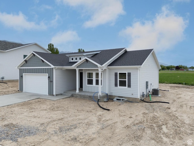 676 E 2450 N, North Logan, UT 84341 - view of front of home with a porch, cooling unit, an attached garage, concrete driveway, and board and batten siding