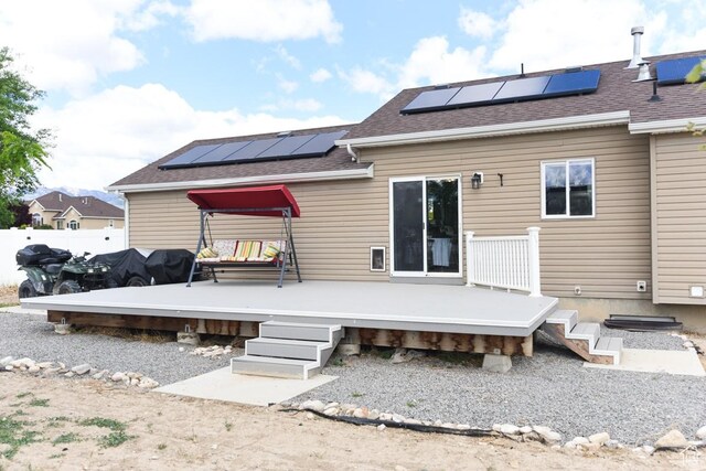 1079 S Legrand Dr, Grantsville, UT 84029 - back of house featuring solar panels, roof with shingles, a wooden deck, and fence