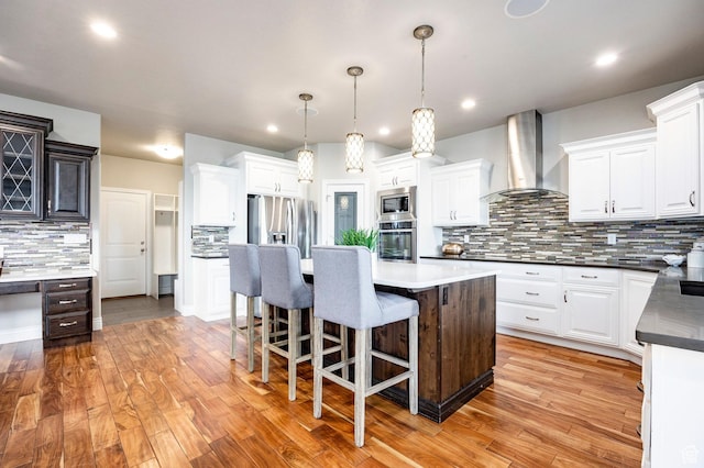 1309 W Atrium Ct W, Farmington, UT 84025 - kitchen featuring appliances with stainless steel finishes, wall chimney range hood, tasteful backsplash, a center island, and white cabinets